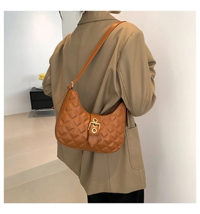 Gros plan du sac hobo matelassé marron avec boucle dorée et bandoulière sur un mannequin