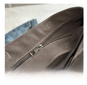 Detail eines glatten silbernen Metallreißverschlusses an einer braunen Canvas-Tasche