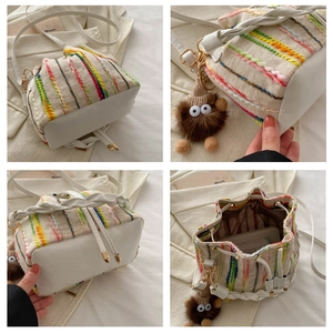 Detail of bohemian bucket bag with colorful embroidery and plush monster charm decoration
