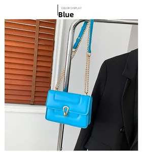 Détail du sac à bandoulière bleu matelassé avec chaîne dorée et fermoir fer à cheval