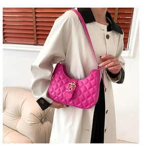 Détail du sac hobo matelassé rose avec boucle dorée sur l'épaule du modèle