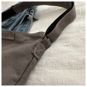 Nahaufnahme der grauen Canvas-Tasche mit Metall-D-Ring und verstärkten Nähten im Detail