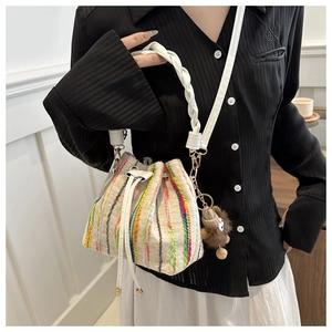Detailed macro view of colorful vertical striped fabric and drawstrings on the bucket bag