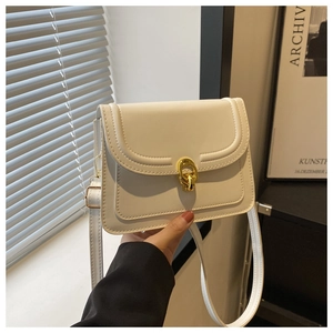 Detail of the white leather square bag with a golden interlocking ring clasp and fine stitching