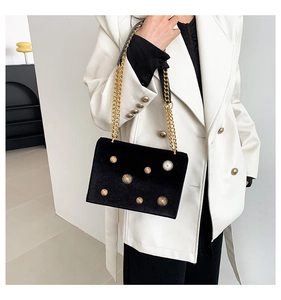 Détail du sac bandoulière en velours noir avec clous étoiles dorés et bandoulière chaîne