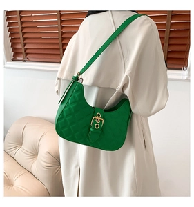 Sac hobo vert matelassé avec boucle dorée porté à l'épaule pour un style quotidien