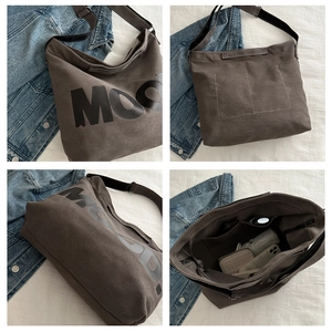 Detaillierte Ansicht einer großen dunkelbraunen Segeltuchtasche mit MOO-Schriftzug