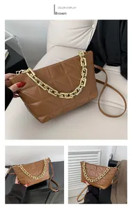 Detail of brown quilted bag with chunky gold chain strap and smooth leather texture