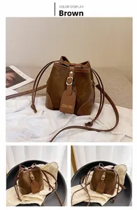 Detail of vintage brown bucket bag with drawstring closure and golden metal buckle