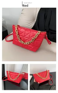 Detail of red quilted faux leather handbag featuring a chunky gold chain and crossbody strap