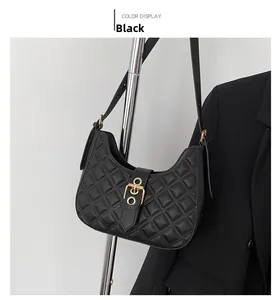 Gros plan sur le sac bandoulière matelassé noir avec boucle dorée sur support métallique