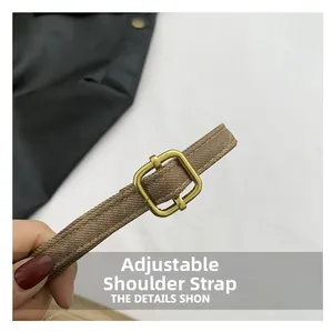 Close-up of adjustable brown woven shoulder strap with gold-tone rectangular metal buckle