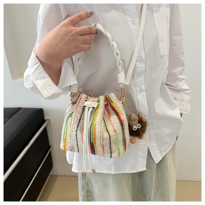 Detailed macro view of colorful vertical stripes and woven handle on bucket bag