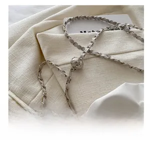 Detail of silver diamond-patterned metal adjustment ball buckle on chain strap