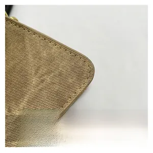 Close-up of golden textured fabric with diagonal patterns and fine stitching detail