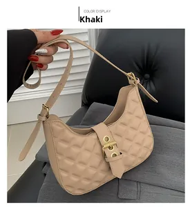 Détail du sac bandoulière kaki avec surpiqûres en losanges et boucle métallique