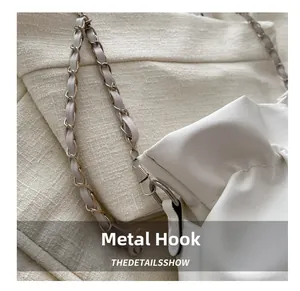 Close-up of premium silver hardware hook and leather chain strap on white bucket bag