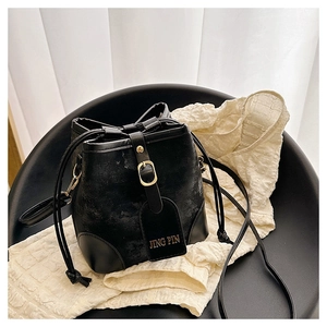 Close-up of black bucket bag showing matte texture with JING PIN gold lettered tag