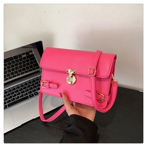 Detail of rose pink leather handbag featuring a secure gold metal buckle and strap