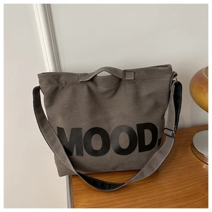 Detail einer großen dunkelgrauen Canvas-Tasche mit MOOD-Schriftzug auf Holzoberfläche