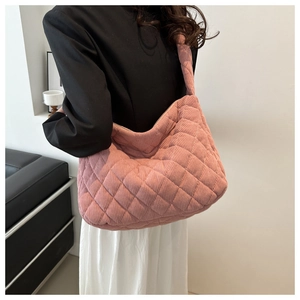 Pink corduroy quilted hobo bag with diamond stitching shown on model shoulder
