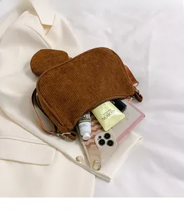 Detailed view of caramel corduroy shoulder bag interior with matching mini round pouch