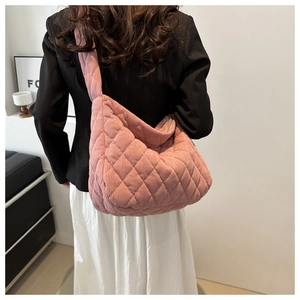 Close-up of pink corduroy quilted crossbody bag with large diamond lattice pattern