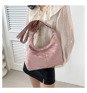 Pink glossy patent leather hobo bag featuring natural crinkled texture and adjustable strap