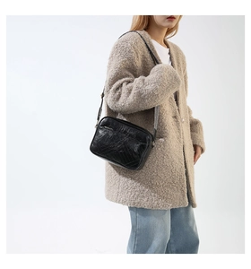 Detail of the V-shaped quilted texture on this stylish black leather crossbody camera bag