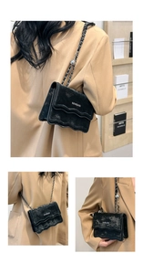 Detail of black wave pattern crossbody bag with chain strap and silver ball charm