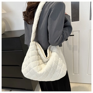 Detailed close-up of quilted off-white corduroy shoulder bag with rhombic stitching