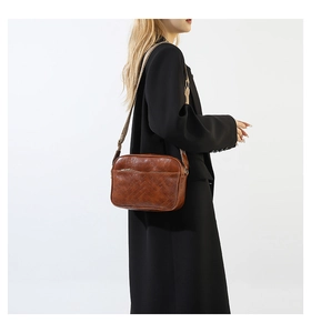 Brown faux leather crossbody camera bag with herringbone quilting and woven wide strap