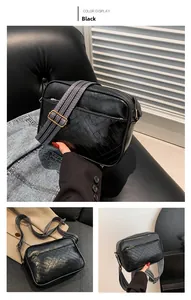 Detail view of black PU leather crossbody bag with V-shaped quilting and striped strap