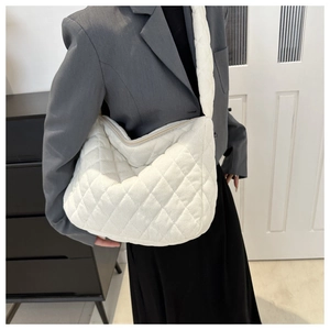Detailed view of a white corduroy quilted hobo bag styled with a minimalist outfit