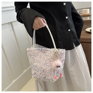 Détails du sac à main blanc à paillettes avec des reflets et un gri-gri rose en peluche