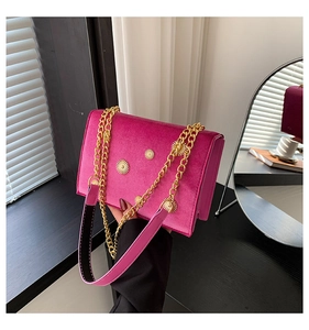 Détail du sac en velours rose avec ornements soleil dorés et bandoulière métallique