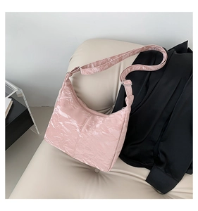 Detailed texture of pink pleated crescent hobo bag featuring unique paper-feel leather finish