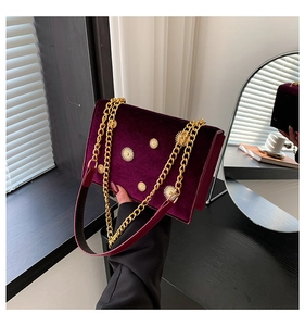 Détail du sac en velours violet avec rivets soleil dorés et bandoulière en chaîne
