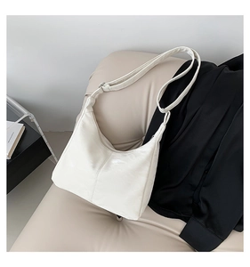 Detail of white moon hobo bag showing crinkled leather texture and adjustable strap
