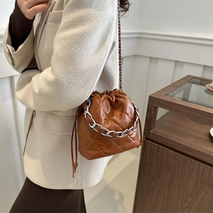 Brown quilted bucket bag with silver chain strap and drawstring closure for women
