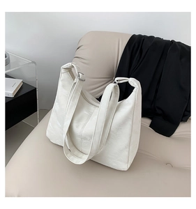 Detail of white wrinkled glossy leather tote bag with wide double shoulder straps