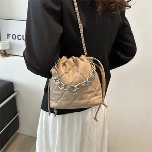 Chic khaki quilted bucket bag with silver chain straps and stylish drawstring closure