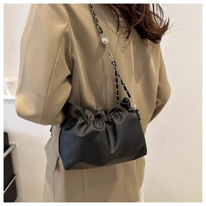 Detail of black pleated cloud bucket bag with silver metal ball and leather chain strap