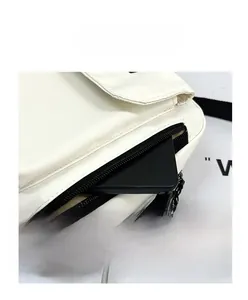 Close-up of front zipper pocket on white nylon shoulder bag with smartphone to show depth