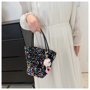 Vue détaillée d'un sac à main à paillettes avec un charmant pompon rose et bandoulière