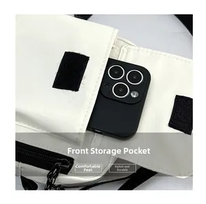 Detailed close-up of a white nylon crossbody bag featuring a front pocket for smartphone storage