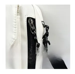 Detail of a white nylon shoulder bag featuring a black zipper with a braided pull cord