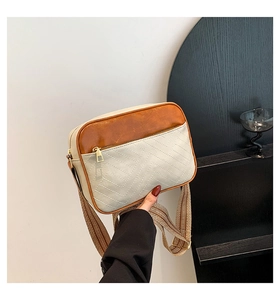 Detailed view of the contrast color crossbody bag featuring herringbone stitching and wide strap