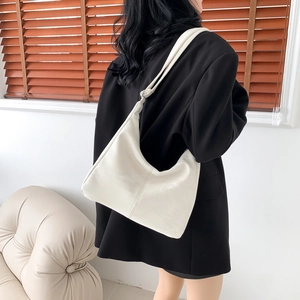 Minimalist white half-moon shoulder bag in soft leather finish for urban office commute