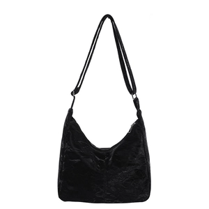 Minimalist black pleated hobo shoulder bag with a textured finish and adjustable strap